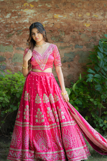 A stunning pink red silk bandhej lehenga featuring marodi and gota patti work lehenga beautifully adorned with fine craftsmanship and exquisite detailing, perfect for festive and special occasions.
