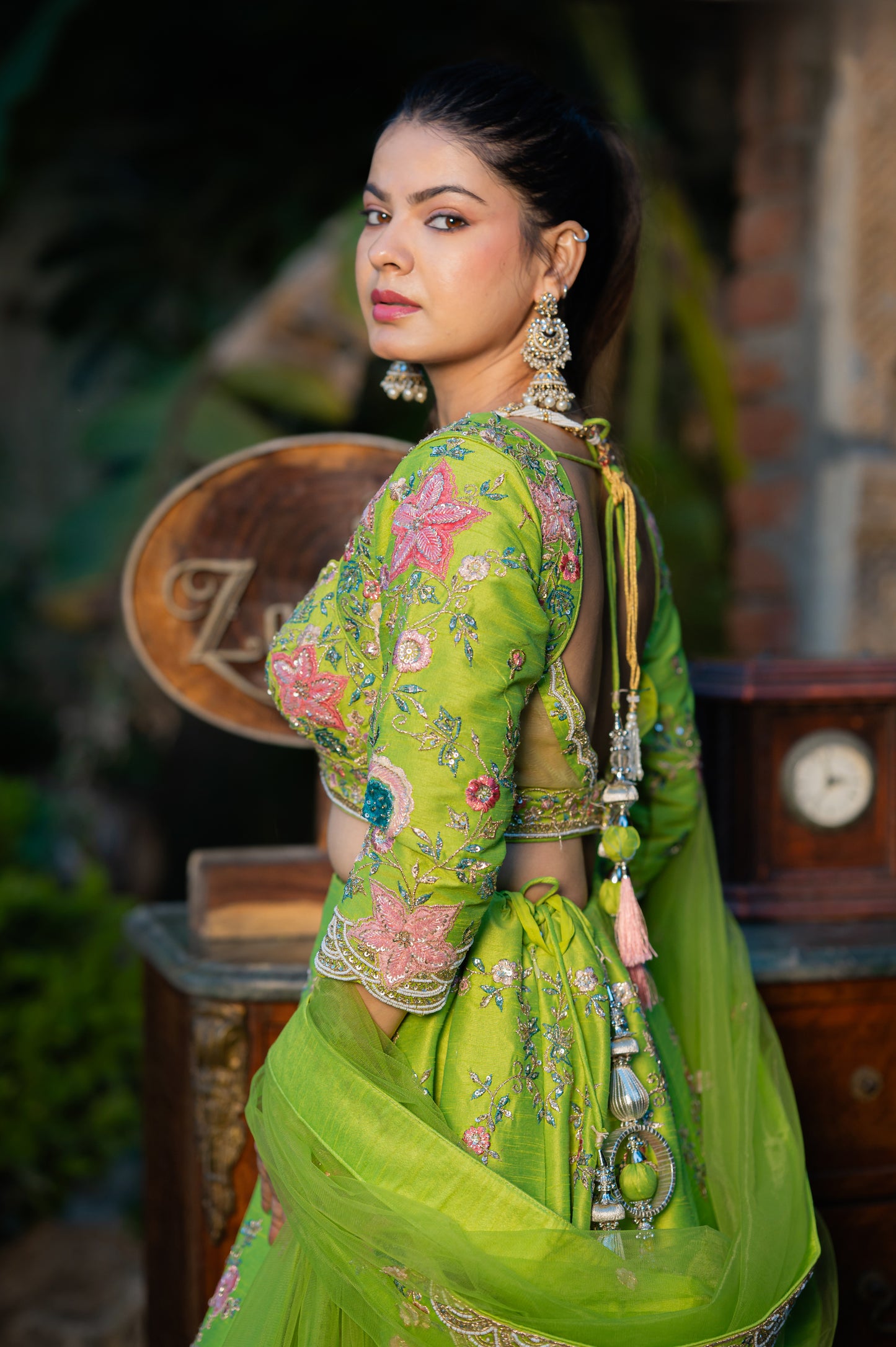 A stunning avocado green raw silk lehenga featuring aari sequins moti work lehenga beautifully adorned with fine craftsmanship and exquisite detailing, perfect for festive and special occasions.