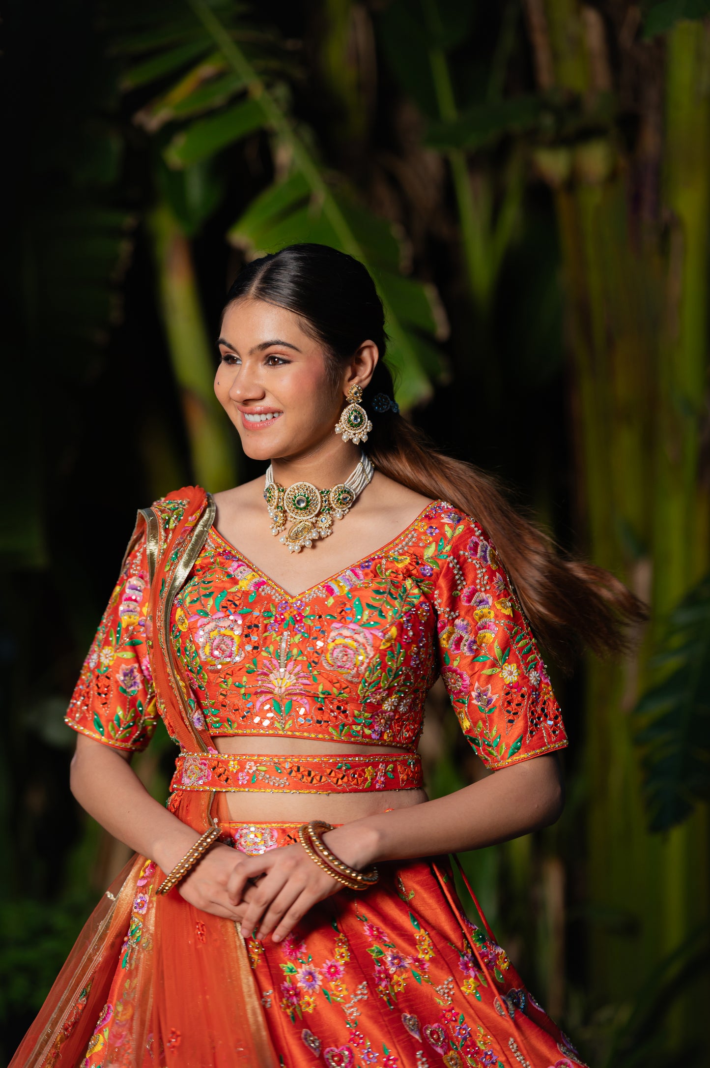 A stunning orangy red raw silk lehenga featuring thread sequins and moti work lehenga beautifully adorned with fine craftsmanship and exquisite detailing, perfect for festive and special occasions.