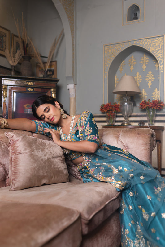 A stunning sea blue velvet lehenga featuring zardozi and moti work lehenga beautifully adorned with fine craftsmanship and exquisite detailing, perfect for festive and special occasions.