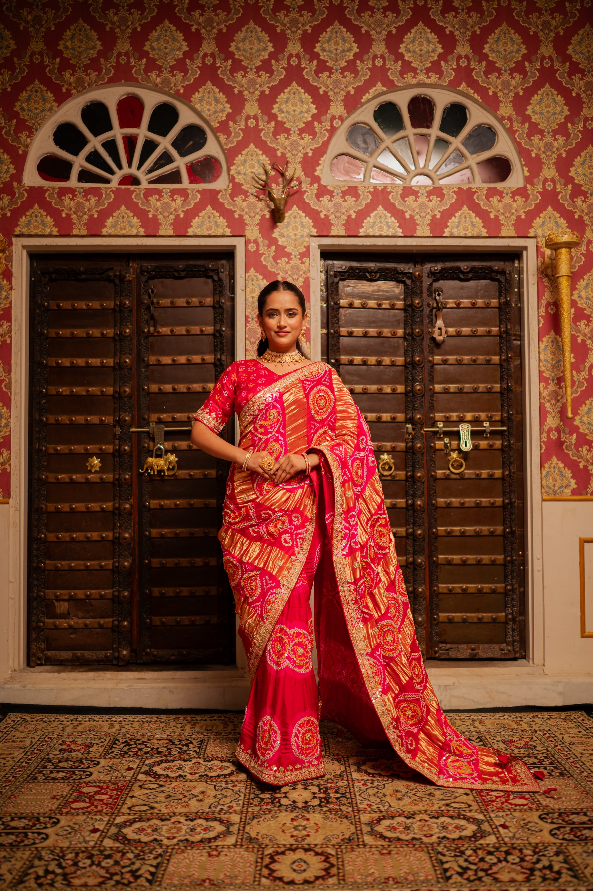 A stunning red pink shaded pure gajji silk bandhani saree featuring gota patti work saree beautifully adorned with fine craftsmanship and exquisite detailing, perfect for festive and special occasions.