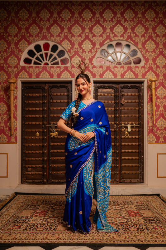 A stunning sky blue multi pure gajji silk bandhani saree featuring gota jaal work saree beautifully adorned with fine craftsmanship and exquisite detailing, perfect for festive and special occasions.