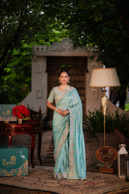 A stunning morning blue pure silk saree featuring aari zardozi and gota patti work saree beautifully adorned with fine craftsmanship and exquisite detailing, perfect for festive and special occasions.