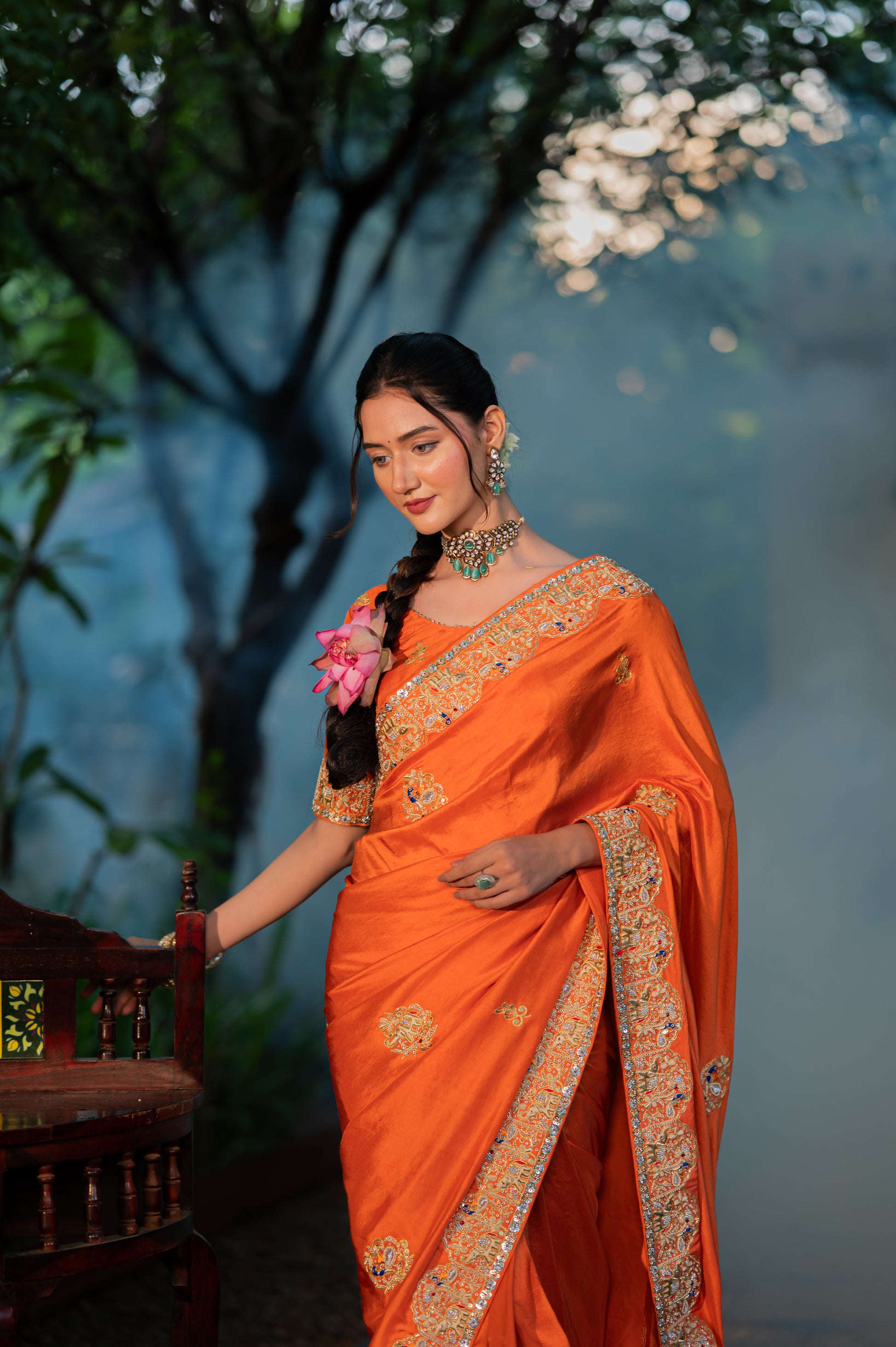 A stunning saffron raw silk saree featuring aari zardozi and thread work saree beautifully adorned with fine craftsmanship and exquisite detailing, perfect for festive and special occasions.