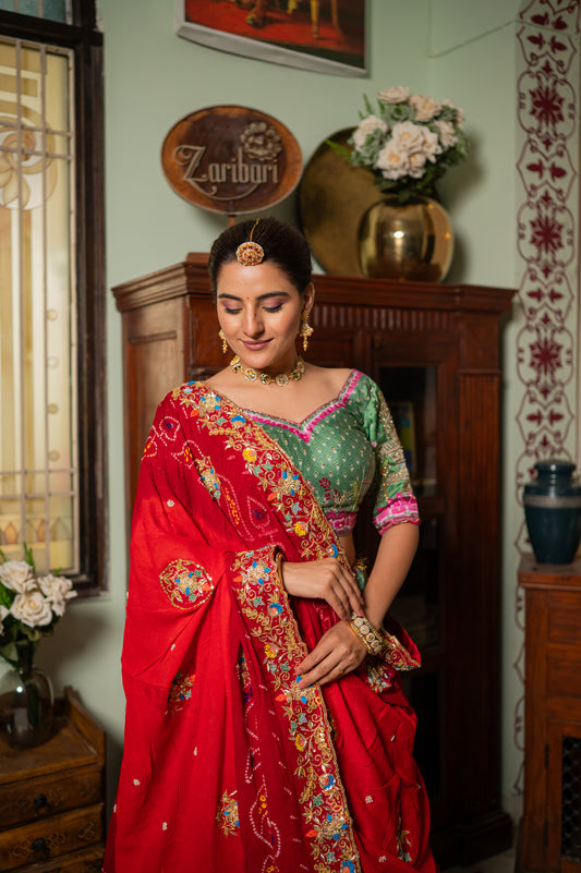 A stunning red pure ojariya bandhej chunari featuring zardozi gota patti thread sequins work chunari beautifully adorned with fine craftsmanship and exquisite detailing, perfect for festive and special occasions.